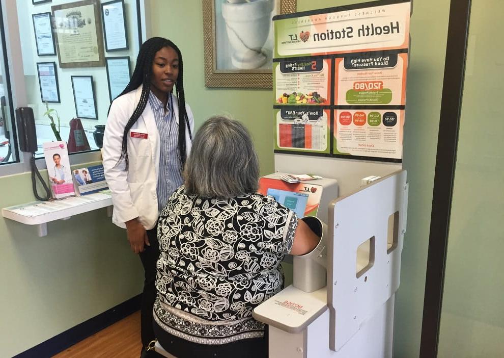 全美学生医药协会(SNPhA)的Jesse Hoe教一名社区成员如何测量她的血压